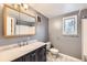 Bathroom with a large mirror, white vanity, and toilet at 26167 De Berry St, Conifer, CO 80433