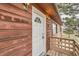 Close up of rustic home's entryway featuring wood siding and outdoor lights at 26167 De Berry St, Conifer, CO 80433