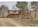 A rustic home with a wooden deck area, and a partially fenced yard at 26167 De Berry St, Conifer, CO 80433