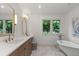 Serene bathroom with double vanity, marble floors and a freestanding soaking tub at 4 Doral Ln, Littleton, CO 80123