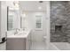 Bathroom featuring double sinks, quartz countertops, and tile shower with built-in niche at 4 Doral Ln, Littleton, CO 80123
