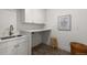 Bright laundry room with white cabinets, a countertop, and a modern sink at 4 Doral Ln, Littleton, CO 80123