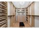 Organized walk-in closet features custom shelving and cabinet storage with a chic ottoman at 4 Doral Ln, Littleton, CO 80123