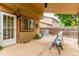 Covered back patio with gravel, outdoor seating, lighting, and entry door at 18206 E Loyola Dr, Aurora, CO 80013