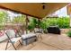 Covered back patio with gravel, outdoor seating, foliage, and grill at 18206 E Loyola Dr, Aurora, CO 80013