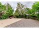 Spacious backyard with concrete patio, gravel ground cover and mature trees, creating a private outdoor space at 18206 E Loyola Dr, Aurora, CO 80013