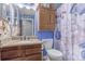 Nautical themed bathroom featuring custom seashell decorated walls, granite countertops, and wood cabinets at 18206 E Loyola Dr, Aurora, CO 80013