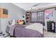 Bedroom with a large bed, dark curtains, dark shelving unit, and gray walls at 18206 E Loyola Dr, Aurora, CO 80013