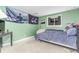 Bedroom with a green painted walls, blue bedding, desk, and natural light at 18206 E Loyola Dr, Aurora, CO 80013