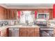 Close up of eat-in kitchen featuring wood cabinets, granite countertops, and stainless steel appliances at 18206 E Loyola Dr, Aurora, CO 80013