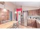 Spacious eat-in kitchen features wood cabinets, granite countertops, and stainless steel refrigerator at 18206 E Loyola Dr, Aurora, CO 80013