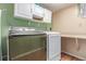 Laundry room featuring modern washer and dryer units, overhead cabinets, and folding counter at 18206 E Loyola Dr, Aurora, CO 80013