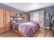 Bright main bedroom features blue wallpaper, wood floors, and a large built-in closet at 18206 E Loyola Dr, Aurora, CO 80013
