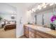 Elegant bathroom with double sinks, a large mirror, and a view of the bedroom at 678 Kryptonite Dr, Castle Rock, CO 80108