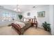 Spacious bedroom with a wooden bed frame, nightstand and large windows at 678 Kryptonite Dr, Castle Rock, CO 80108