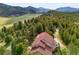Scenic aerial perspective of a luxurious residence surrounded by mountain views and dense forest at 1425 Autumnwood Ln, Evergreen, CO 80439