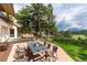 Backyard patio featuring a table with seating and beautiful views of surrounding forest at 1425 Autumnwood Ln, Evergreen, CO 80439