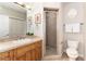 Bathroom featuring a single vanity, framed floral art, and tiled walk-in shower at 1425 Autumnwood Ln, Evergreen, CO 80439