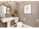 Charming powder bathroom with pedestal sink and artwork at 1425 Autumnwood Ln, Evergreen, CO 80439