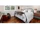 Comfortable bedroom with wrought iron bed frame, hardwood floors, and window view at 1425 Autumnwood Ln, Evergreen, CO 80439
