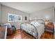 Cozy bedroom featuring a metal frame bed, hardwood floors, and natural light from the window at 1425 Autumnwood Ln, Evergreen, CO 80439