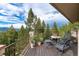 Outdoor patio with table and chairs showcasing scenic mountain views surrounded by lush trees at 1425 Autumnwood Ln, Evergreen, CO 80439