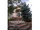 Inviting front entrance with brick steps leading to a modern, light colored home with large windows and mature trees at 1425 Autumnwood Ln, Evergreen, CO 80439
