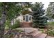 Inviting front entrance with stone walkway and mature trees providing shade and curb appeal at 1425 Autumnwood Ln, Evergreen, CO 80439