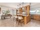 Bright kitchen with a center island, wooden cabinetry, and adjacent dining area at 1425 Autumnwood Ln, Evergreen, CO 80439