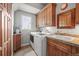 Efficient laundry room features tile floors, sink, cabinets, and updated appliances at 1425 Autumnwood Ln, Evergreen, CO 80439