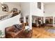 Open-concept living room with hardwood floors, fireplace, staircase, and comfortable furnishings at 1425 Autumnwood Ln, Evergreen, CO 80439