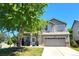 Charming two-story home featuring a well-manicured lawn, mature tree, and a two-car garage at 3554 S Jebel Cir, Aurora, CO 80013