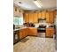 Functional kitchen featuring oak cabinets, stainless steel appliances, and durable floors at 3554 S Jebel Cir, Aurora, CO 80013