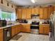 Functional kitchen featuring oak cabinets, stainless steel appliances, and durable floors at 3554 S Jebel Cir, Aurora, CO 80013