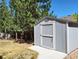 Backyard shed with ample space for storage surrounded by mature trees and a lawn at 3554 S Jebel Cir, Aurora, CO 80013