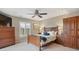 This bedroom is furnished with a wooden bed frame, ceiling fan, shuttered windows and coordinating wooden cabinets at 9528 Pendio Ct, Highlands Ranch, CO 80126