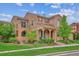 Charming two-story stone home featuring a manicured lawn and inviting covered porch at 9528 Pendio Ct, Highlands Ranch, CO 80126