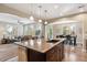 Open concept kitchen flows into the living and dining areas with island seating at 9528 Pendio Ct, Highlands Ranch, CO 80126