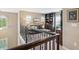 Relax in the upstairs living area with cozy seating, bookshelves, and a view of the staircase at 9528 Pendio Ct, Highlands Ranch, CO 80126