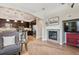 Open living space connecting a modern kitchen and living area with a fireplace focal point at 9528 Pendio Ct, Highlands Ranch, CO 80126