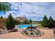 Beautiful community pool area with fountain and surrounding lounge chairs, trees and landscaping at 9528 Pendio Ct, Highlands Ranch, CO 80126