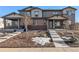 Inviting townhome with covered porch, stone accents, and manicured landscaping at 7267 S Millbrook Ct, Aurora, CO 80016