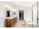 Bright bathroom features a double vanity, large mirror, soaking tub, and walk-in closet for ample storage at 2209 Lupine Pl, Erie, CO 80516