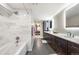 Modern bathroom with long countertop, double vanity, marble shower, and tiled floors at 2209 Lupine Pl, Erie, CO 80516