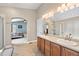 Bathroom vanity with double sinks, large mirror, and access to the Primary bedroom at 2209 Lupine Pl, Erie, CO 80516