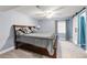 A cozy bedroom features soft blue walls, a ceiling fan, and a stylish barn door entrance to the ensuite bathroom at 2209 Lupine Pl, Erie, CO 80516