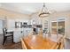 Bright kitchen and dining area with a modern chandelier and a sliding glass door to the backyard at 2209 Lupine Pl, Erie, CO 80516