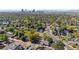 An aerial view of a residential neighborhood with mature trees, showcasing the Denver skyline at 3102 N Columbine St, Denver, CO 80205