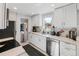 Bright, renovated kitchen with white cabinets, stainless steel appliances, and modern finishes at 3102 N Columbine St, Denver, CO 80205