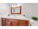 Bathroom showcasing a wooden vanity, mirror, and tiled backsplash, with decorations at 12120 Melody Dr # 308, Westminster, CO 80234
